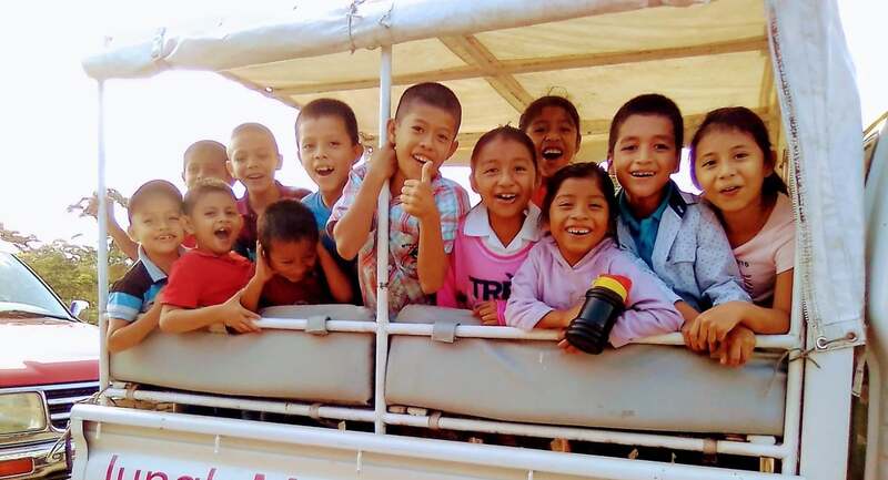 A group of twelve children on a vehicle.